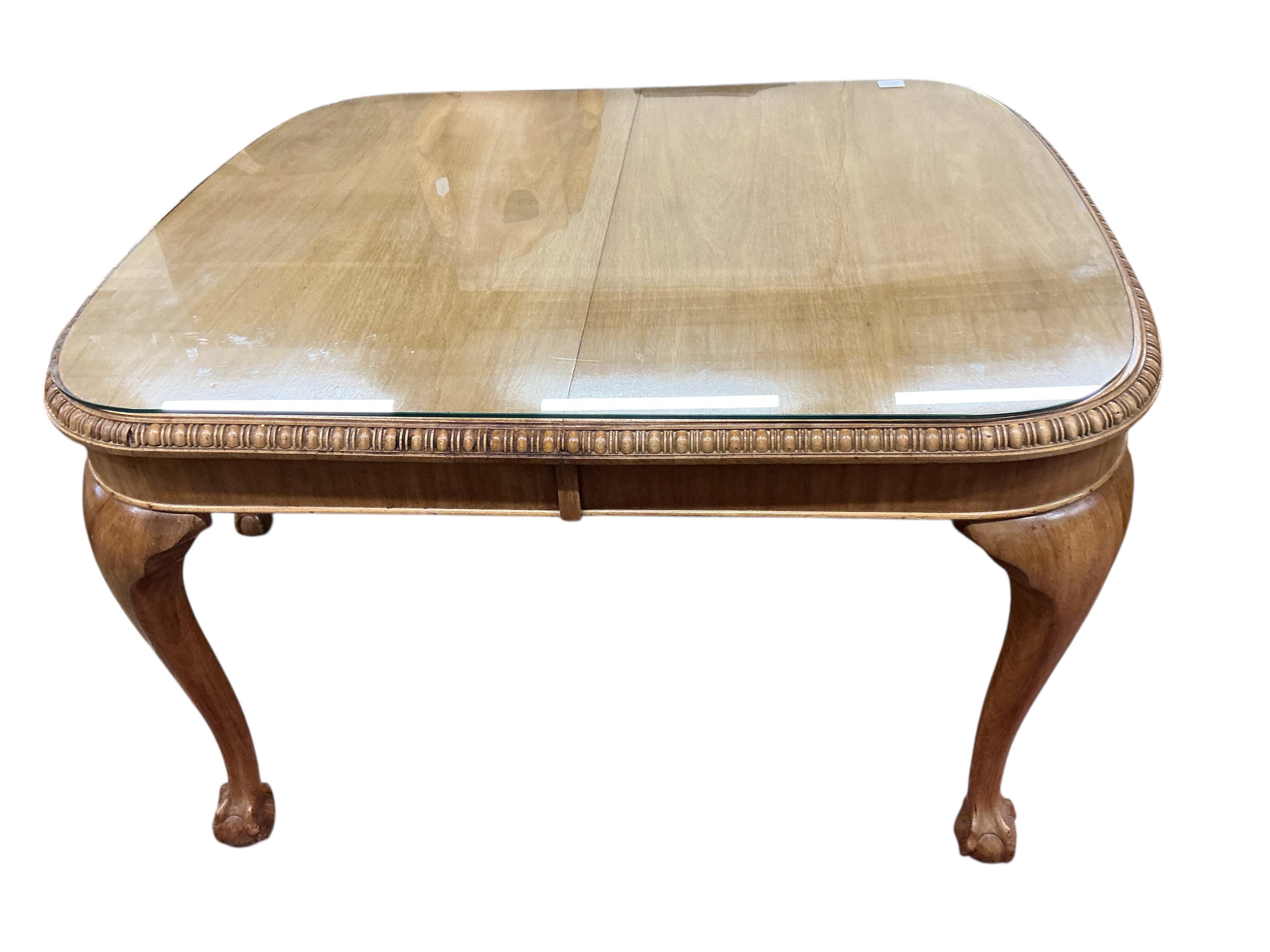 A George III style walnut extending dining table, (no leaves), 124cm, depth 104cm, height 74cm and six dining chairs, two with arms